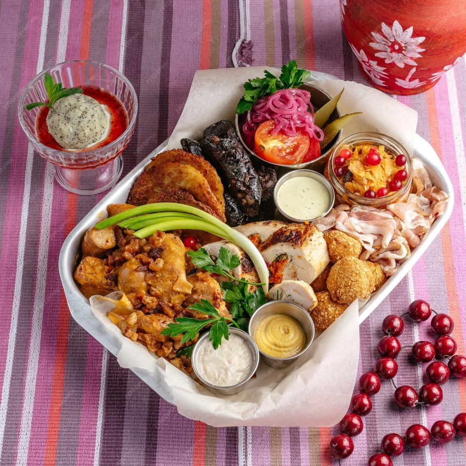 A large platter of various Peruvian dishes, including meats, fried items, and sauces, with a dessert.